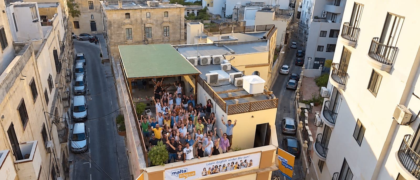 La azotea de Maltalingua en St Julian's vista desde arriba, con los estudiantes saludando y las calles del barrio alrededor